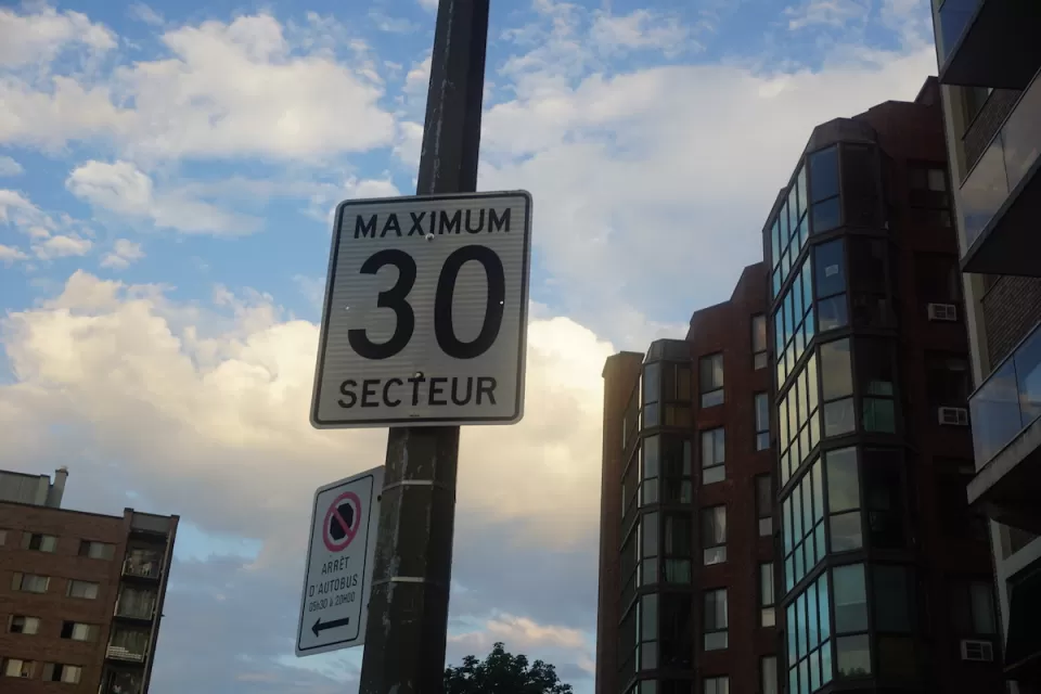 Close-up of "Maximum 30 Secteur" speed limit sign on pot in Quebec, Canada.